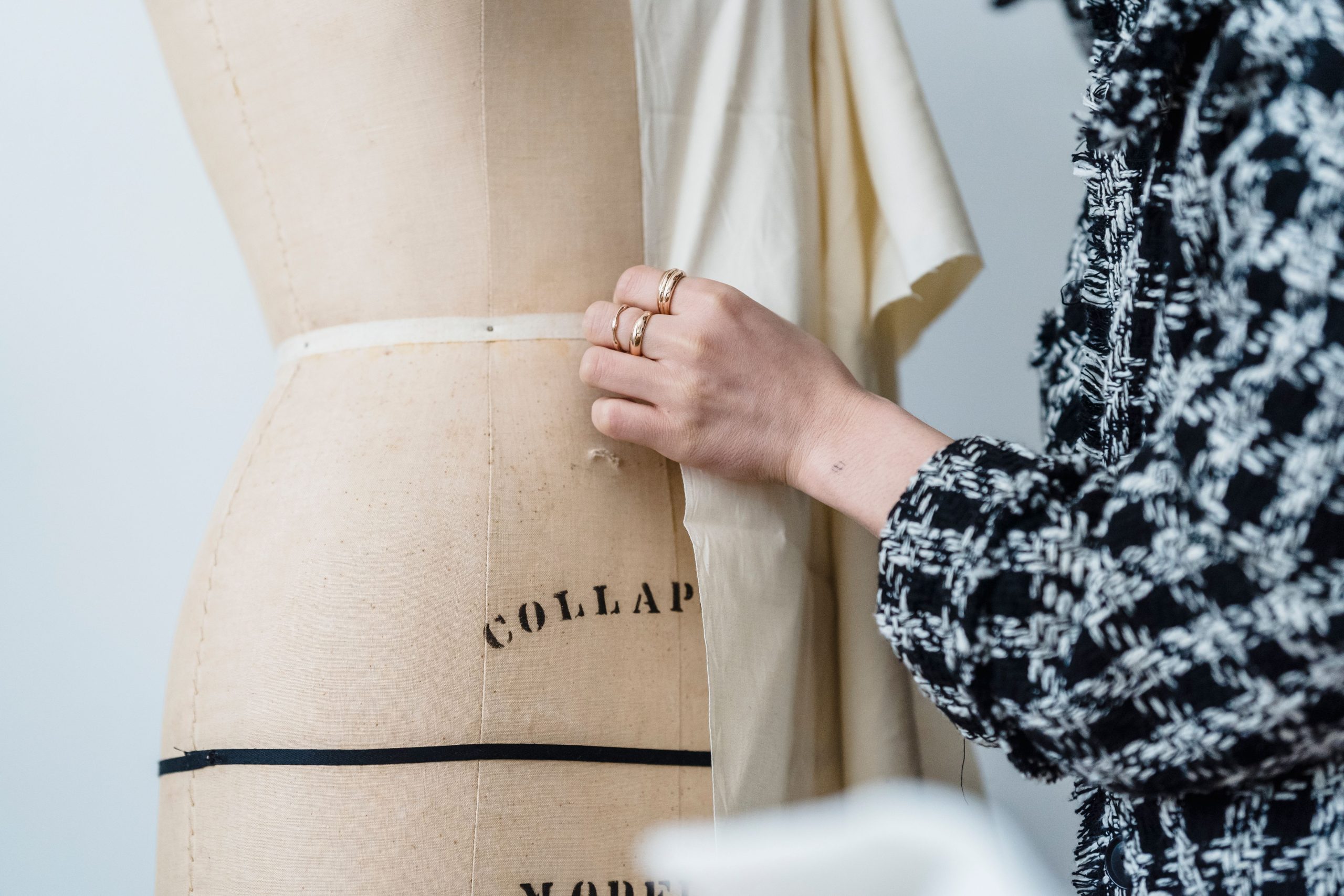 Mains ajustant un vêtement en atelier de haute couture