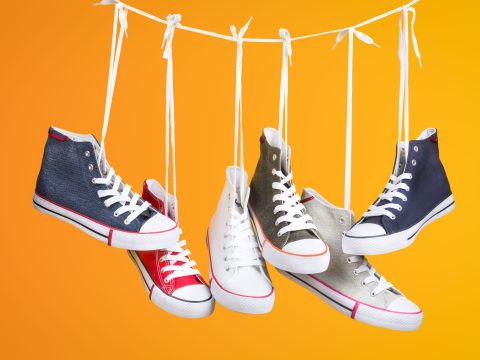 Paire de baskets colorées suspendues sur fond orange