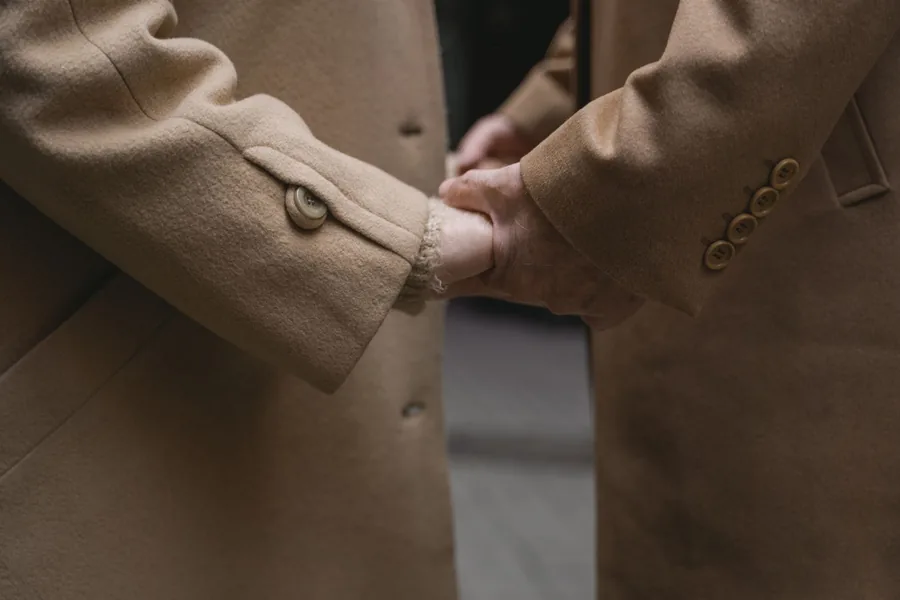 Manteau en laine camel, main réglant la manche