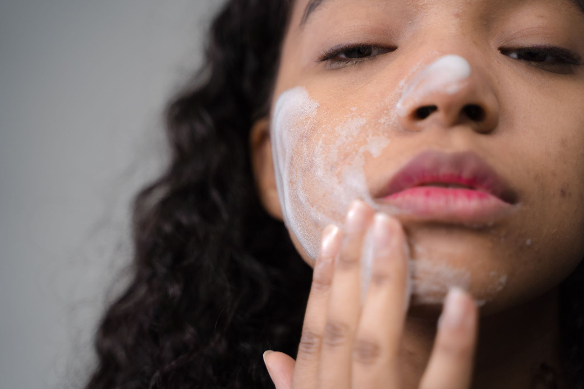 femme qui applique une crème sur le visage dans le cadre de sa routine du matin