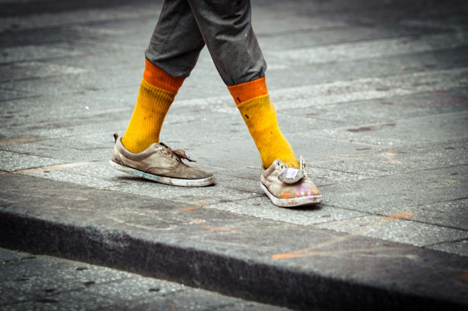 Cheville d'homme en baskets, chaussettes visibles sous le pantalon