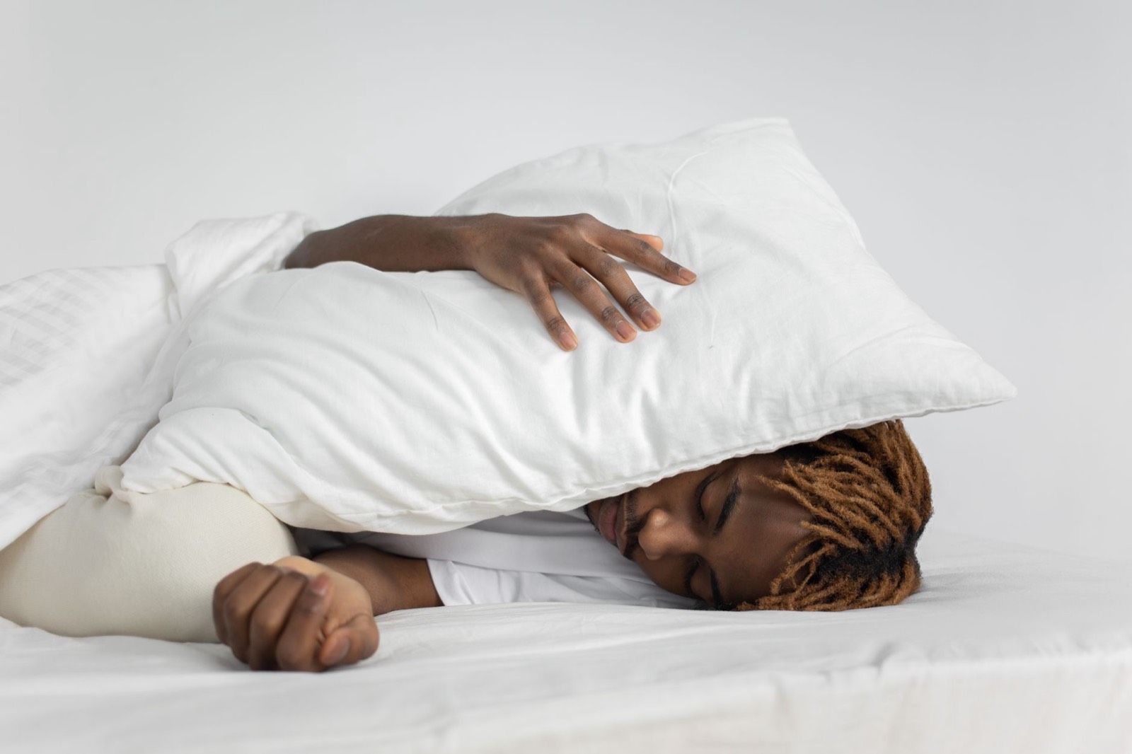 Personne dormant sur le côté, tête posée sur un oreiller, dans une lumière douce de matin